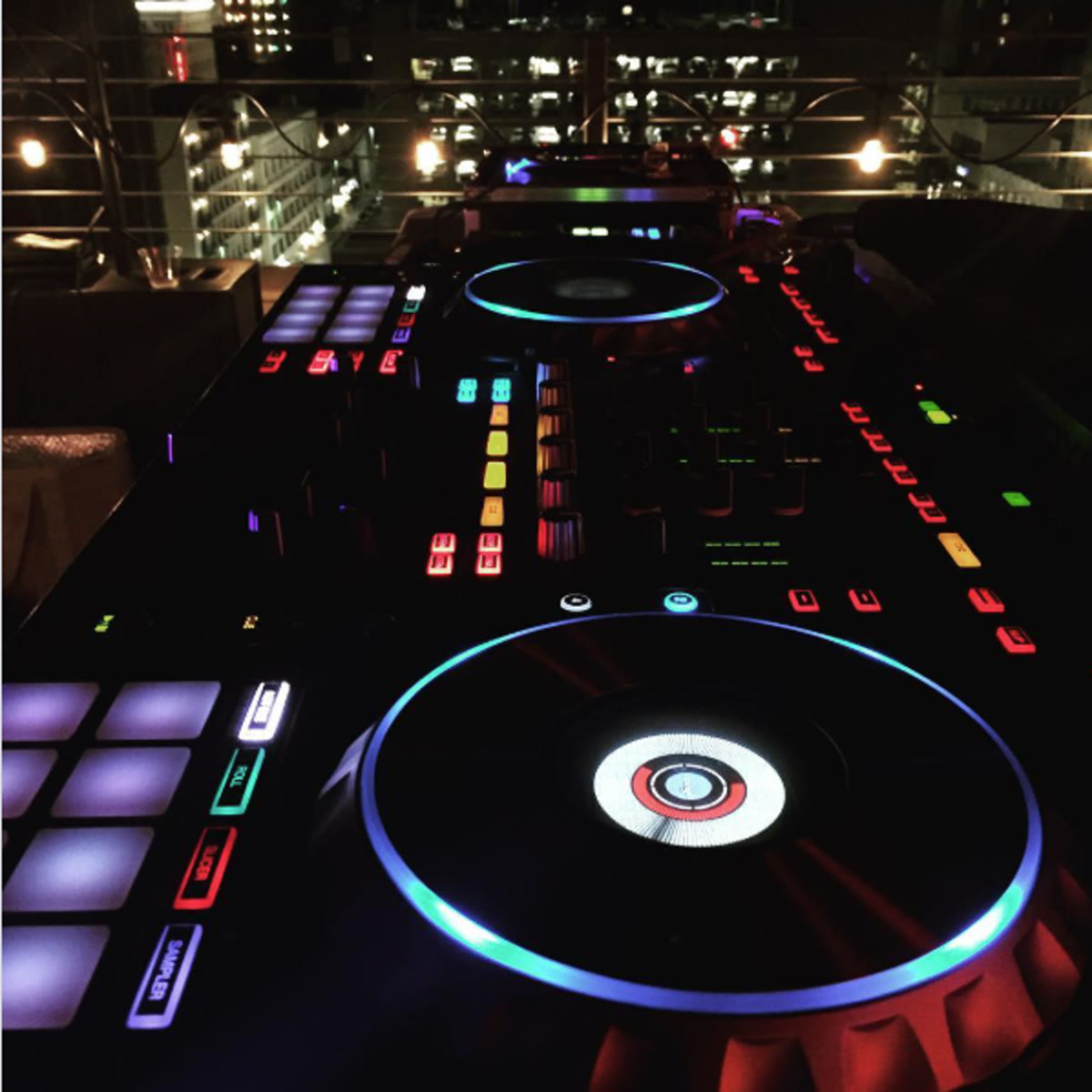 C&W Music Enterprise DJ controller set up on a rooftop at night above city lights